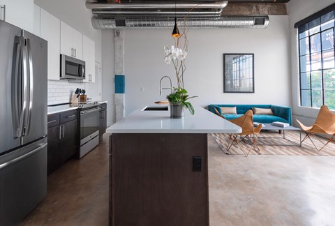 a kitchen with an island and a living room with a blue couch